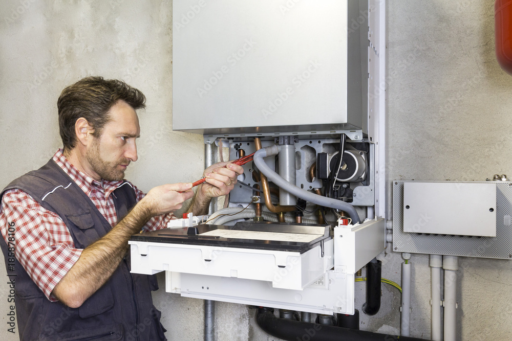 Obraz premium plumber repairing a condensing boiler