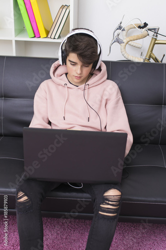 young man with computer on the sofa at home photo