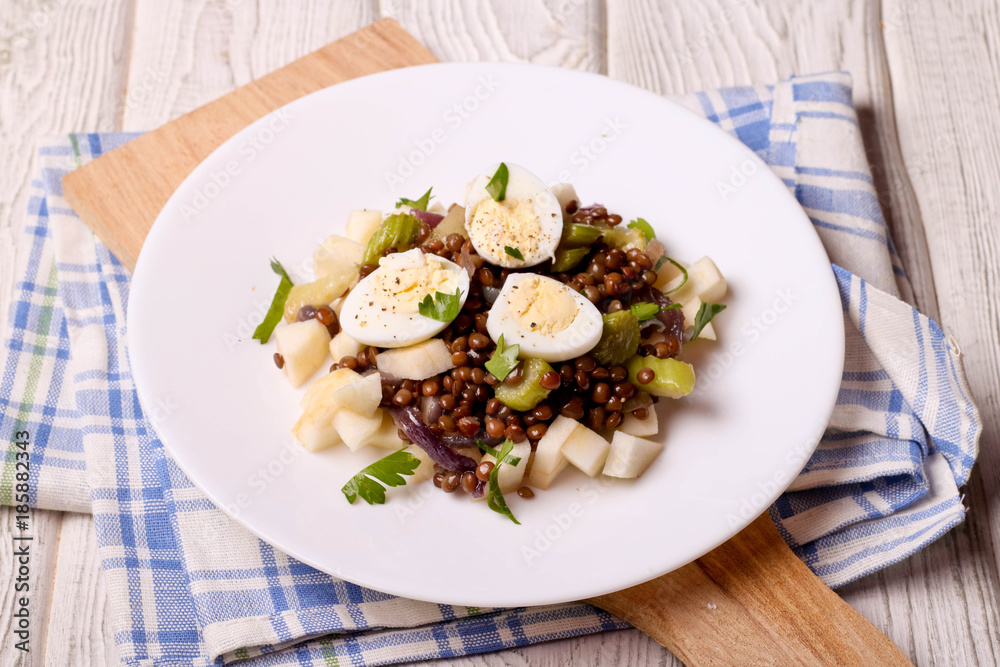 Lentils salad with apple and egg on a white plate Lentils salad with apple and egg on a white plate