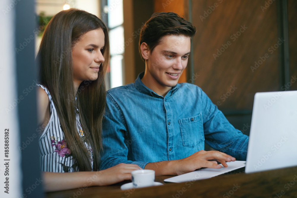 Beautiful Couple Working On Notebook In Cafe. Beautiful Couple Working On Notebook In Cafe.