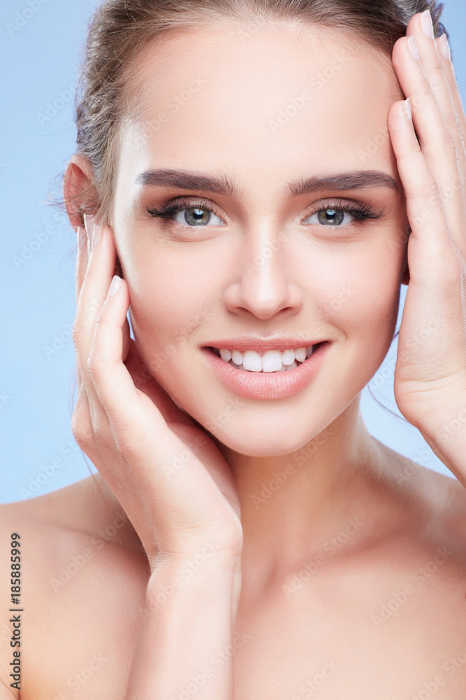 Smiling woman touching face with both hands Smiling woman touching face with both hands