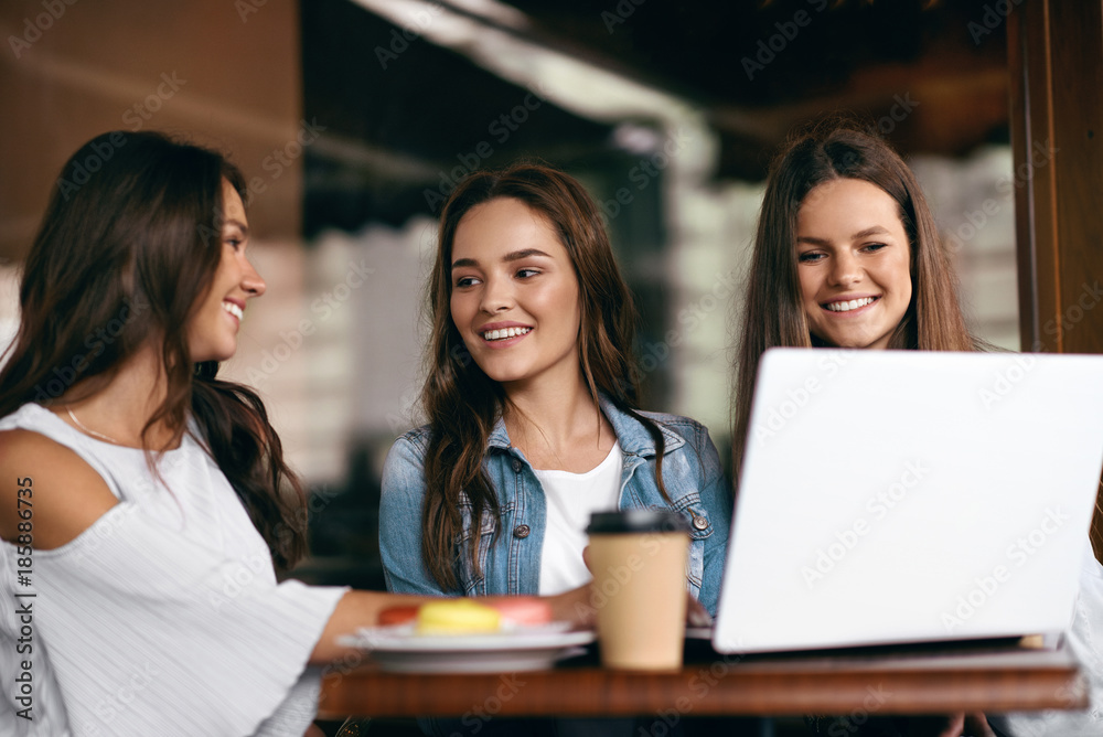 Girls In Cafe. Happy Friends Using Computer. Girls In Cafe. Happy Friends Using Computer.