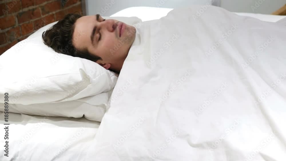 Young Man Falling Asleep in Bed at Night
