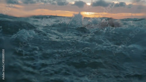 slow motion of professional swimmer swimming crawl outdoor on sunset, front view