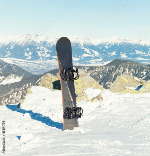 Male snowboarder holding board in hands at the very top of a mountain - outdoors shot