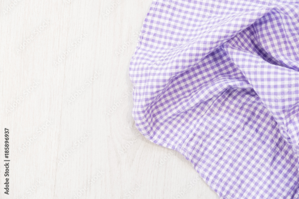 folded cyan tablecloth on bleached wooden table