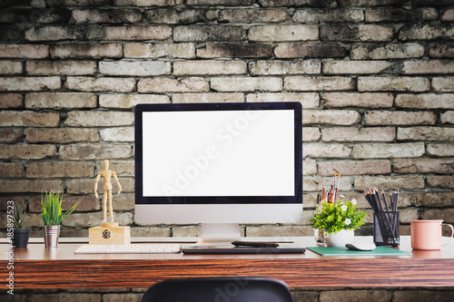 Stylish workspace with desktop and laptop computer, office supplies, houseplant and books at home or studio. Blank screen for graphics display montage.