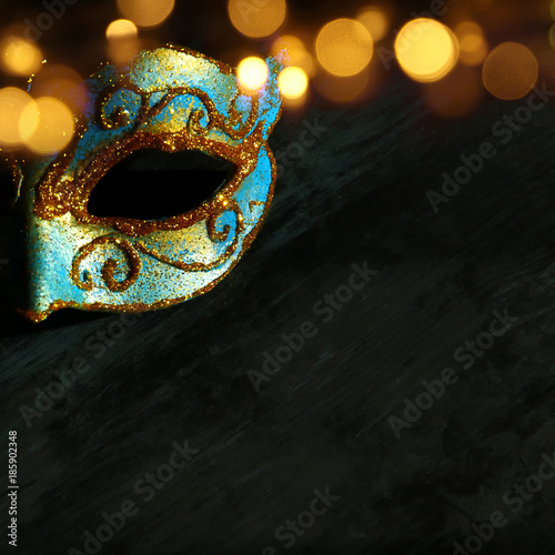 Image of elegant blue and gold venetian, mardi gras mask over dark background