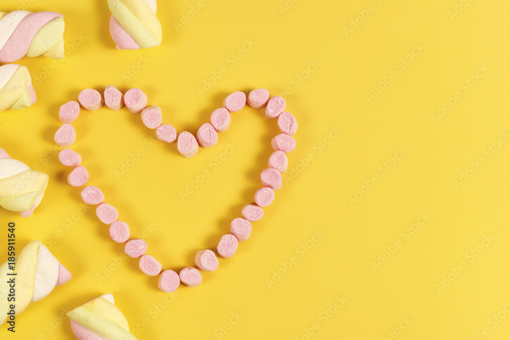 Fototapeta premium marshmallow sweets placed in heart shape.valentine's day and love concept on yellow background