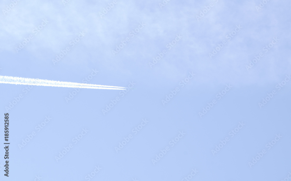 Flying airplane on the blue sky leaving white lines behind Flying airplane on the blue sky leaving white lines behind