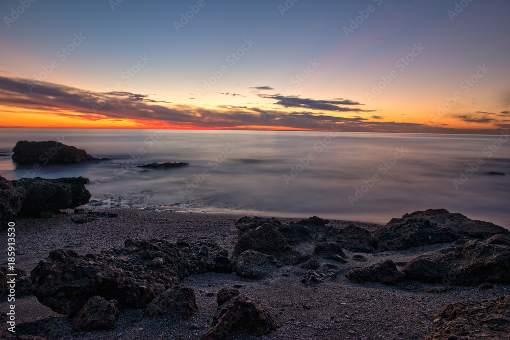 The calm sea in a very cloudy sunset