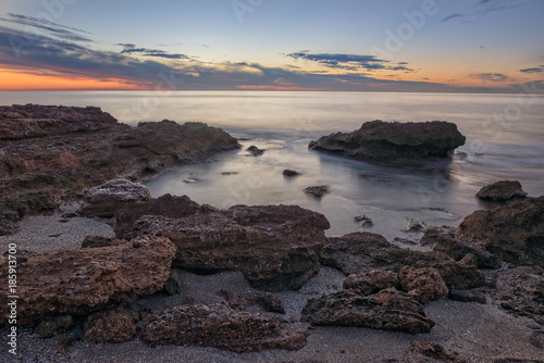 The calm sea in a very cloudy sunset