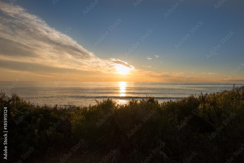 The calm sea in a very cloudy sunset