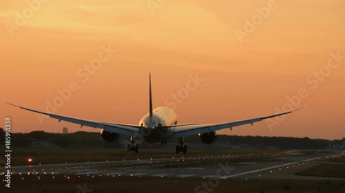 Widebody twin engine airplane landing in the early morning photo