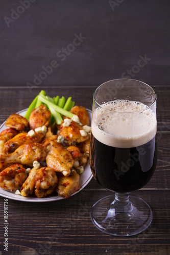Beer and chicken wings buffalo with blue cheese and celery sticks, vertical