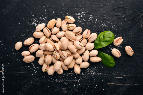 Pistachio nuts on a dark wooden background. Healthy snacks. Top view. Free space for text.
