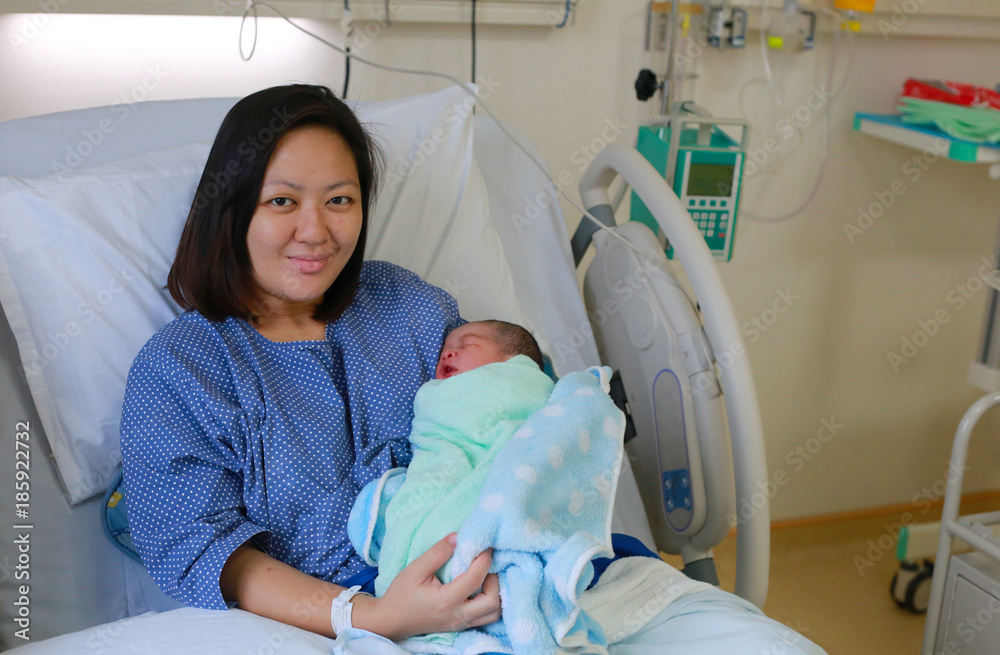 Mother holding her newborn child after labor Mother holding her newborn child after labor