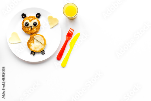 Funny breakfast for children. Meal with cheesecake in shape of owl. White background top view copyspace