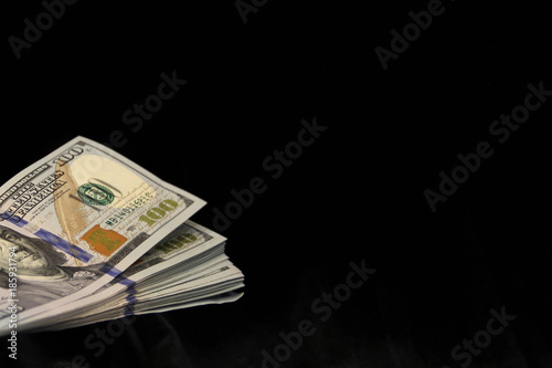 A pile of American dollars on a black background. American money on dark  fabric. Dollars lie on the black surface. Black money. Copy space. Bribe in  dollars in the shade. Stock Photo |