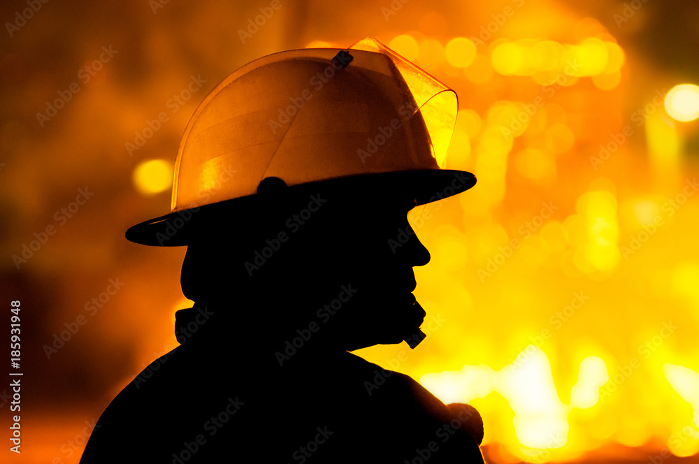 Fototapeta premium firefighter in action , silhouette