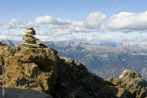 landscape: pyramid of Zen stones resting on top of Mount Zeda, border between Italy and Switzerland, mountains on the horizon with autumn colors, forest, Alps, autumn, sun, clouds, Italy © Angela