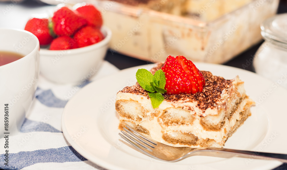Homemade tiramisu cake decorated with strawberries Italian cuisine, Selective focus Homemade tiramisu cake decorated with strawberries Italian cuisine, Selective focus