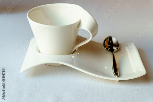 designer white Cup on a saucer with a teaspoon