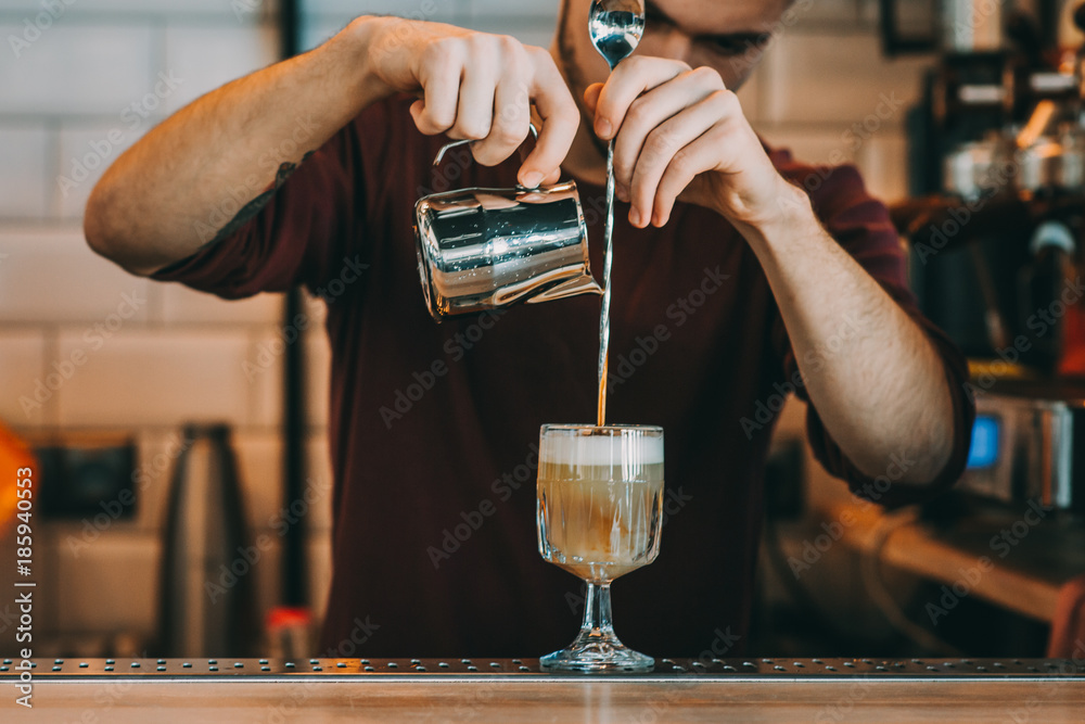 Expert barman is making cocktail