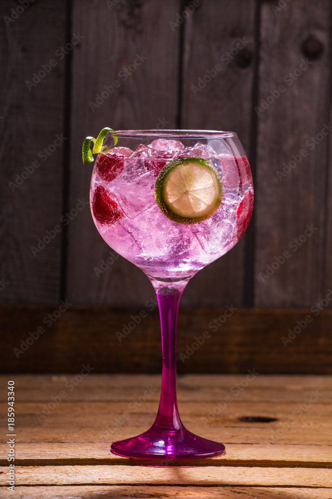 Pink tonic gin with raspberries, wooden background