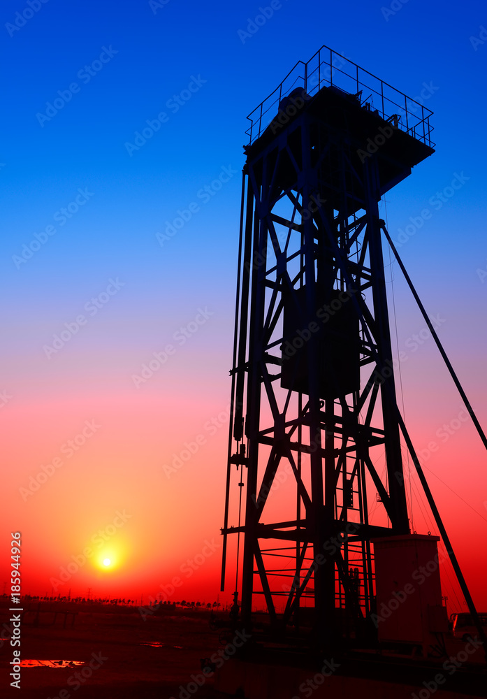 Tower mounted pumping unit under the sunset, close-up Tower mounted pumping unit under the sunset, close-up