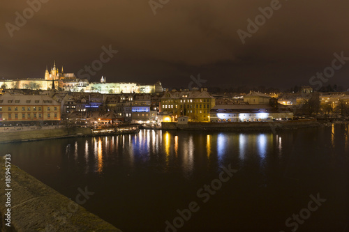 Night colorful snowy Christmas Prague Lesser Town with gothic Castle from Charles Bridge, Czech republic
