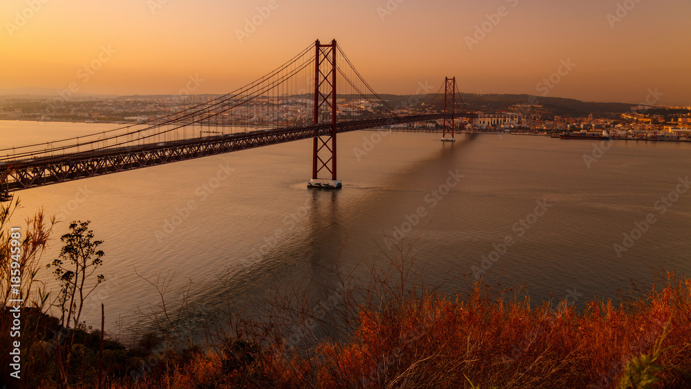 Spectacular twilight aerial shot of Lisbon, Portugal overseeing the entire downtown, the Tagus river, the Cristo Rei and the Ponte 25 de Abril suspension bridge.