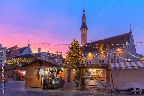 Decorated and illuminated Christmas tree and Christmas Market at Town Hall Square or Raekoja plats at beautiful sunrise, Tallinn, Estonia.