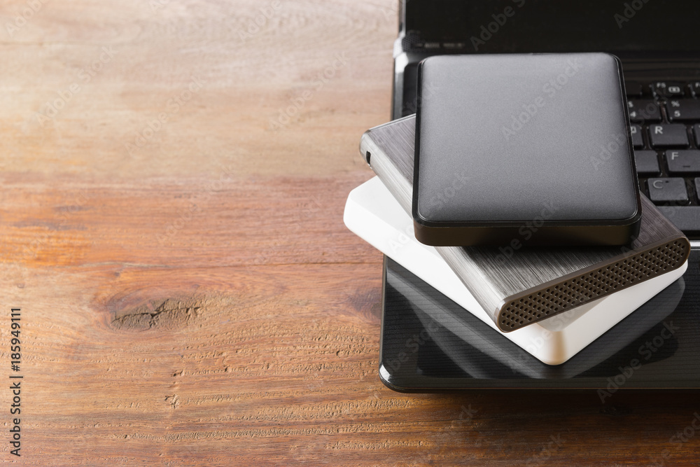 stack of portable external harddrive on laptop computer with copy space for text. data and information file storage technology concept. stack of portable external harddrive on laptop computer with copy space for text. data and information file storage technology concept.