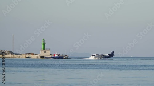 Harbour Hydroplane slides on waves when dangerous sea traffic situation. Pirce with green sea beacon photo