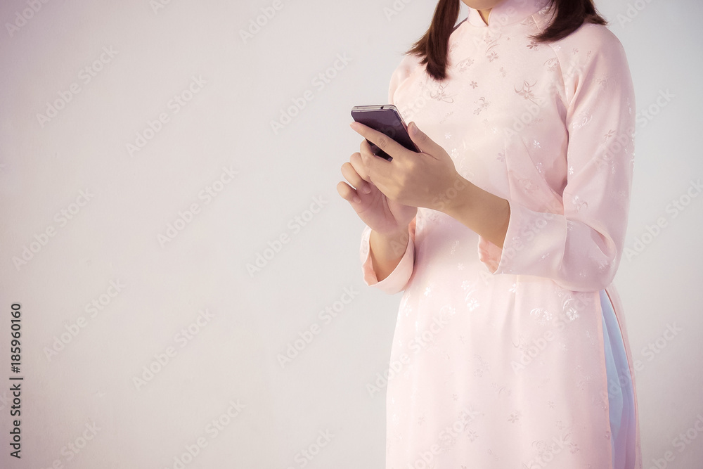 beautiful woman in pink dress and vietnam hat holding smartphone. beautiful woman in pink dress and vietnam hat holding smartphone.