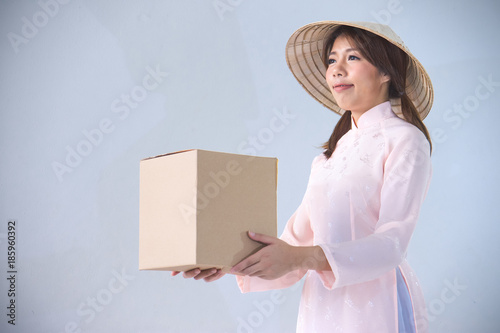 beautiful woman in pink dress and vietnam hat holding box photo