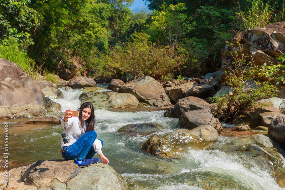 Woman hiking around mountains near the river at spring time.