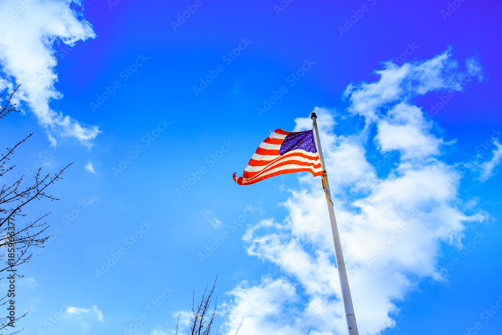 American flag waving under a blue sky with clouds American flag waving under a blue sky with clouds
