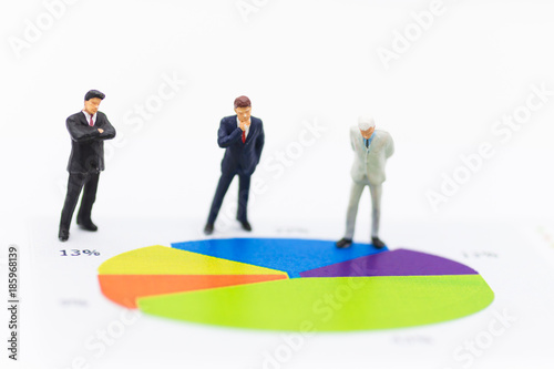 Miniature people : Businessmen stand to see the profit board of the company, check the progress of the job. Use as a business concept.