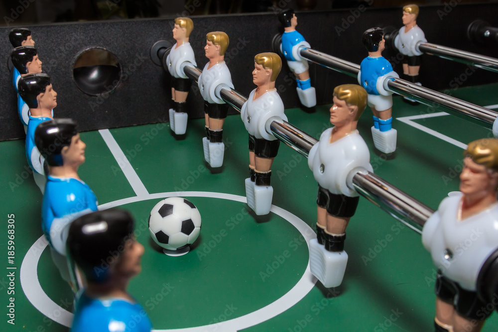 Soccer table game. Green field with blue and white plastic footballers Soccer table game. Green field with blue and white plastic footballers