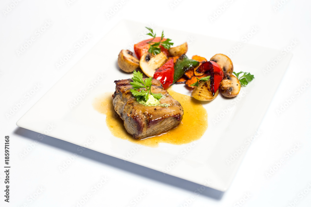 meat with grilled vegetables on a plate on white background meat with grilled vegetables on a plate on white background