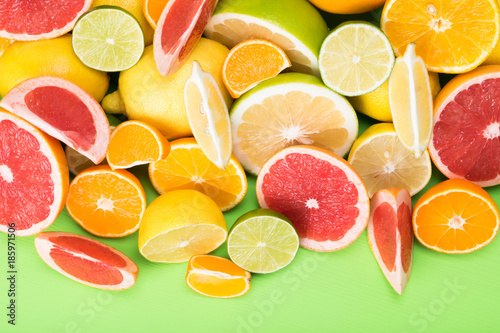 summer juicy mix of citrus fruits on a bright green board