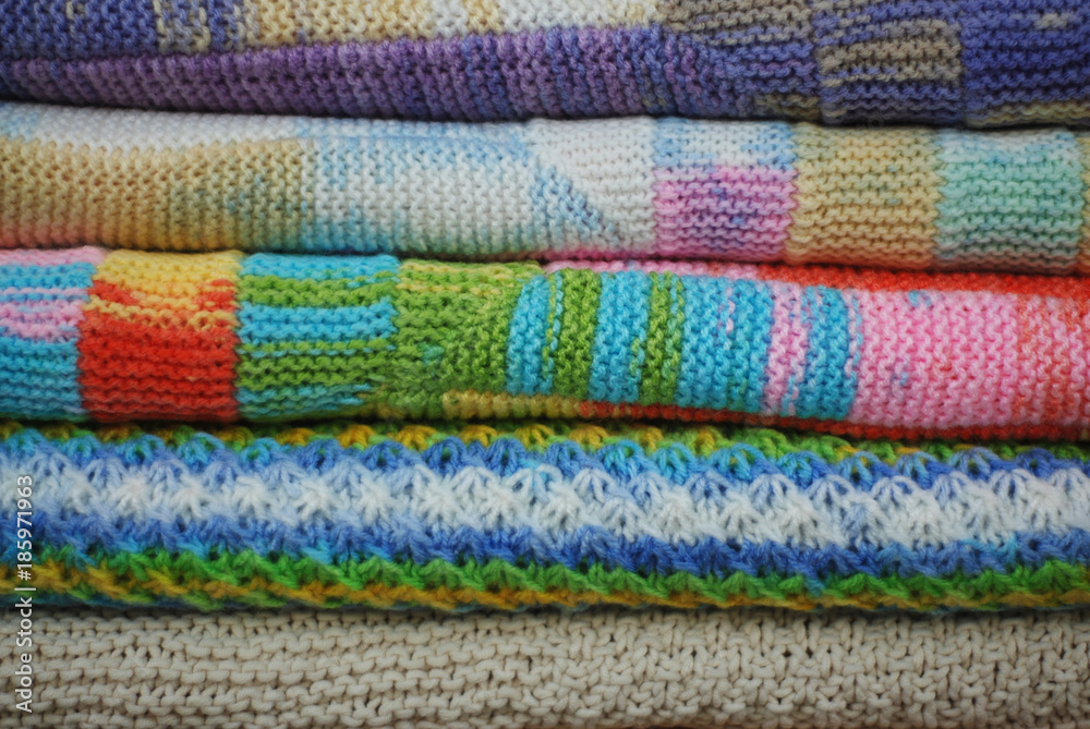 Stack of various colorful knitted blankets. Winter style. Isolated on white background Stack of various colorful knitted blankets. Winter style. Isolated on white background