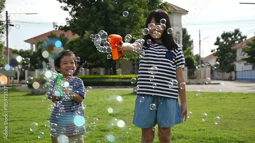 Cute Asian children Shooting Bubbles from Bubble Gun in the park slow motion 