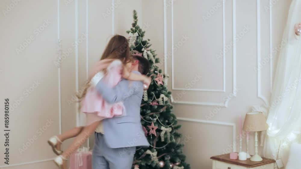 Child hugs his father near the Christmas tree Child hugs his father near the Christmas tree