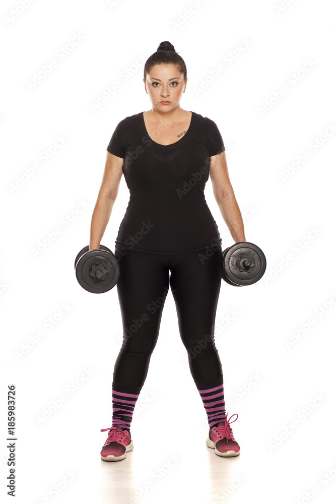 Chubby woman posing with weights in fitness clothing on white background Chubby woman posing with weights in fitness clothing on white background