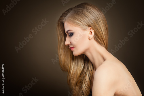 Healthy Blonde Woman with Long Hair on Dark Background with Copy space