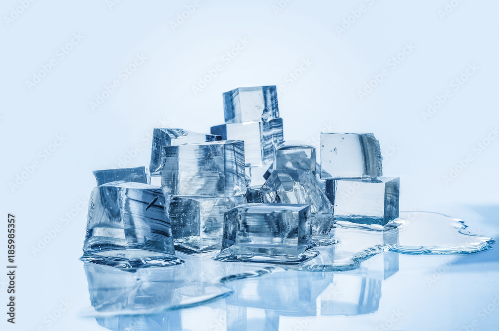 Obraz premium Melting ice cubes on blue background