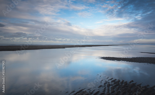 Clouds at Dutch beach with reflections